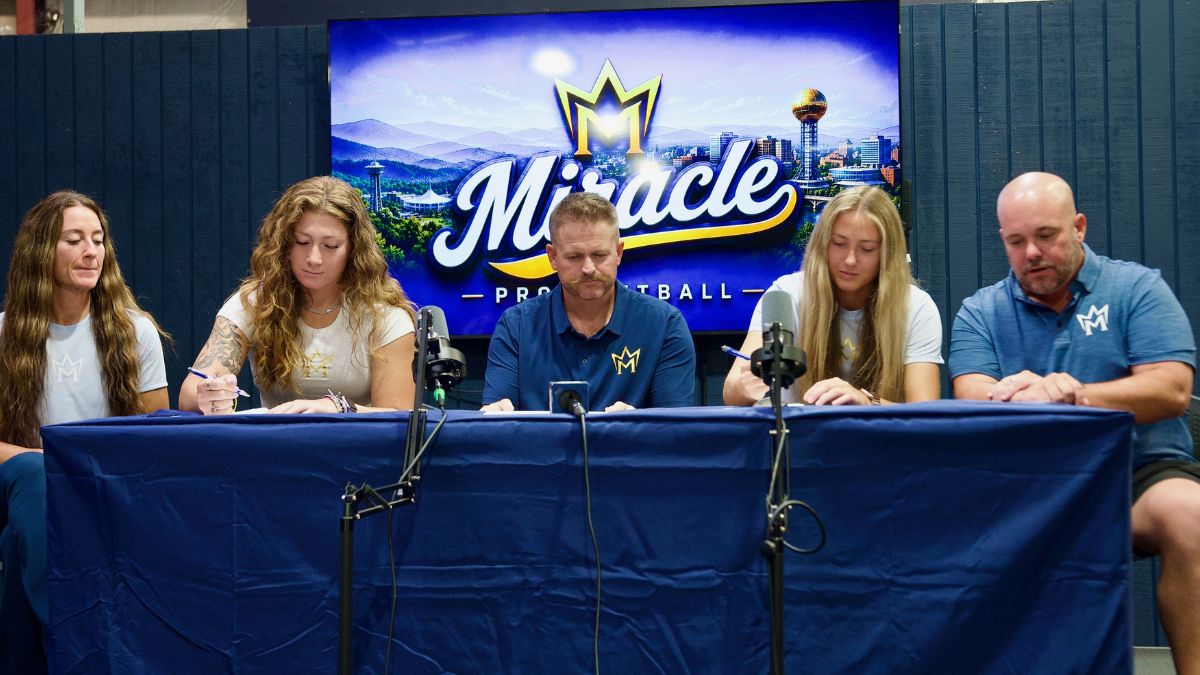 Maddie Moore and Makayla McClain sign with the Knoxville Miracle alongside General Manager Eugene Bleecker and Head Coach Craig Snider.